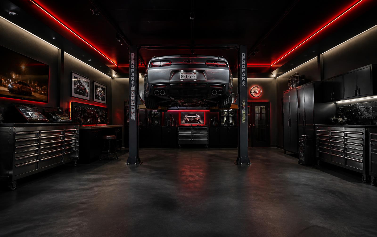 Clean private garage interior with a car on a lift under red accent lighting